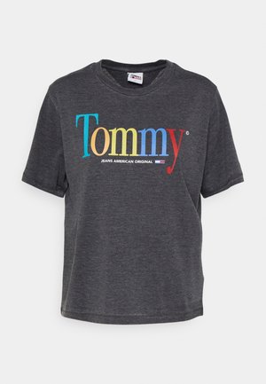 Camiseta de algodón gris con un colorido logo de "Tommy" y "JEANS AMERICAN ORIGINAL" impreso debajo. Manga corta y corte relajado.
