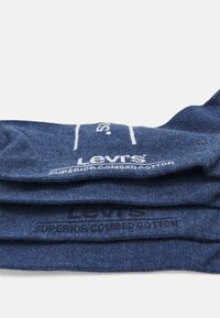 Meias azuis de ganga, feitas de algodão penteado superior, com o logótipo e texto da Levi's impressos em branco. Textura suave e design tricotado.