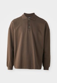 Brun langermet polo skjorte med krage, tre knapper og ribbede mansjetter. Laget av mykt bomullsmateriale med en avslappet passform.