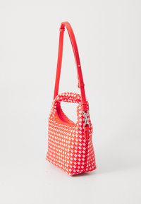 Borsa intrecciata in rosso brillante e bianco, con manico superiore e tracolla rimovibile. Tessuto liscio con chiusura a zip.