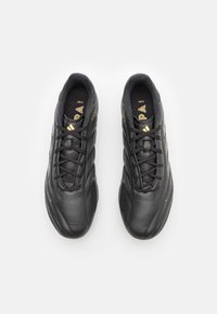 Scarpa da calcio in pelle nera con texture liscia, caratterizzata da dettagli dorati e un design classico con lacci. Punta arrotondata e profilo basso.