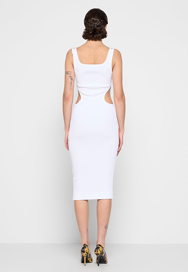 Vestido blanco sin mangas con una silueta ajustada, longitud a la mitad de la pantorrilla y detalles de corte a los lados. Textura suave.