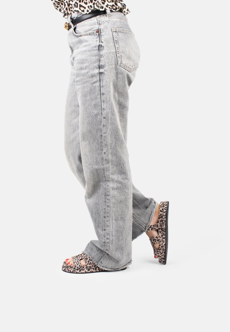 Gray denim straight-leg jeans paired with open-toe leopard print sandals. Sandals feature cutouts and a black sole.