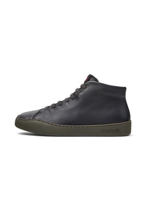 Baskets montantes en cuir noir avec semelle en caoutchouc verte, détails de couture subtils et design à lacets. Présente le logo Camper sur le côté.