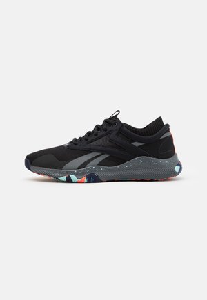 Schwarzer sportlicher Sneaker mit Mesh-Obermaterial, grauen Seitenstreifen, gesprenkelter grauer Sohle und mehrfarbiger gemusterter Außensohle, von der Seite auf weißem Hintergrund dargestellt.