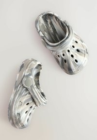 Sabots en motif camouflage gris, fabriqués en matériau léger, dotés de perforations pour la ventilation et d'une sangle arrière pour un maintien sécurisé.