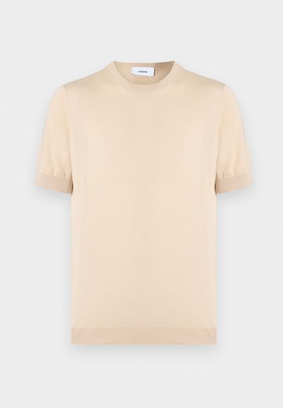 Μπεζ πλεκτό πουκάμισο με κοντά μανίκια και λαιμόκοψη στρογγυλή. Το ύφασμα φαίνεται μαλακό, με ριμπ διακοσμήσεις στις μανσέτες και στο τελείωμα. Μινιμαλιστικό σχέδιο.