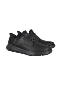 Zapatos deportivos negros con un upper sintético liso, acentos texturizados, collar acolchado y diseño de cordones. Suela de goma flexible con agarre.