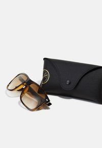 Ochelari de soare cu un model de broască țestoasă, dotati cu lentile maro cu degradé, având un cadru rectangular și accente metalice. Împreună cu o carcasă din piele texturată neagră.