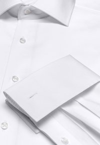 Witte overhemd met een klassiek ontwerp, strakke kraag en knoopsluiting met parelmoer knopen; gladde stof met gestructureerde manchetten.