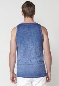 Kék gradient tank top, enyhén texturált anyagból, kerek nyakkivágással, ujjatlan tervezéssel és minimális varrási részletekkel.