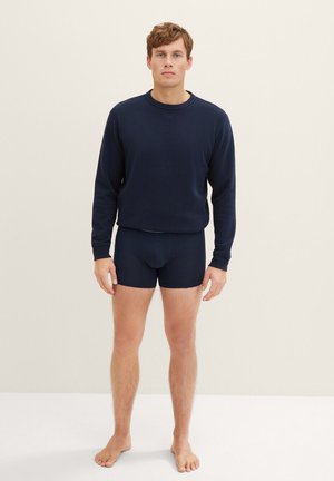 Sudadera azul marino y pantalones cortos a juego, fabricados en un tejido suave y elástico. Corte casual con cuello redondo y sin logotipos ni patrones visibles.