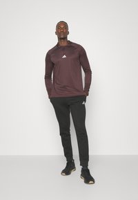 adidas Sportswear ESSENTIALS - Teplákové kalhoty - black