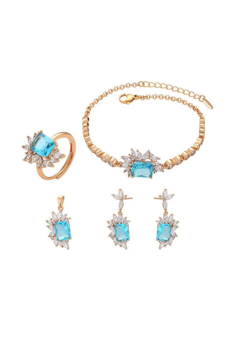 Un set di gioielli in oro composto da un anello, un bracciale, orecchini e un ciondolo. Ogni pezzo presenta una pietra blu centrale circondata da piccole pietre trasparenti.