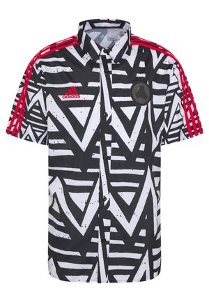 Chemise à manches courtes à motifs géométriques noirs et blancs avec logo Adidas rouge et trois bandes rouges sur chaque épaule.