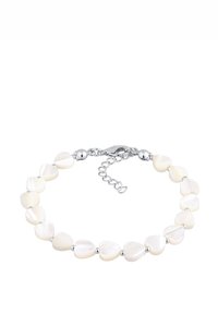 Vita hjärtformade snäckskalspärlor som alternerar med silvermetall-accenter, avslutat med en silverlåsning och justerbar kedja.