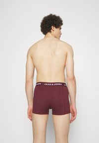 Burgunderfarbene Boxershorts mit einem schwarzen Bund, auf dem das Logo "JACK & JONES" prangt. Weicher Stoff mit leichtem, körperbetontem Design.