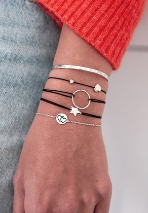 Juostelių rinkinys, kuriame yra juodas virvutė ir sidabro akcentai. Įeina žvaigždutė, apskritimas, širdelės ir spaustas metalinis apyrankė. Textūruoti paviršiai.