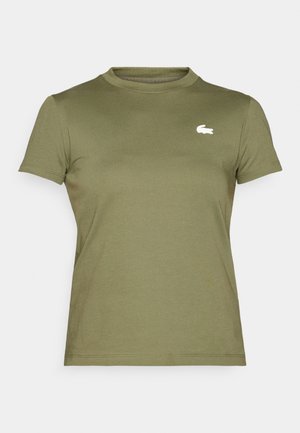 T-shirt à manches courtes vert olive en coton doux, avec un col rond et un petit logo crocodile blanc sur la poitrine.
