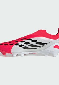 Ποδοσφαιρικό παπούτσι στυλ κάλτσας σε κόκκινο, άσπρο και μαύρο με υφή στην επιφάνεια και διαμορφωμένες τάπες σε λευκή σόλα.