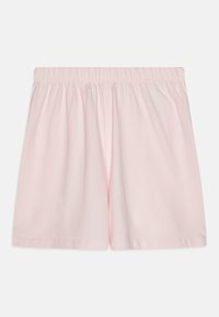 Απαλά ροζ βαμβακερά σορτς με ελαστική μέση. Απλός σχεδιασμός, μήκους μέχρι το γόνατο, χωρίς ορατά σχέδια ή μεταλλικά στοιχεία. Μαλακή υφή.