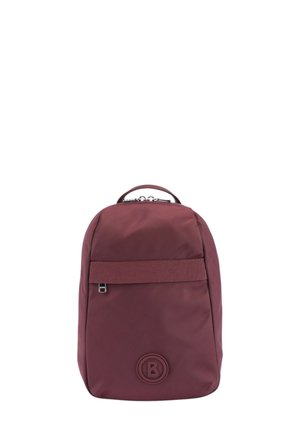 Sac à dos en tissu bordeaux avec un design arrondi, une sangle frontale, un logo en relief et une poignée supérieure. Texture lisse avec un style minimaliste.