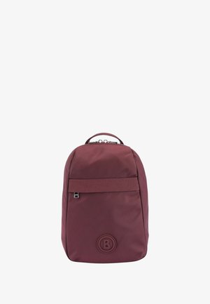 Zaino in tessuto bordeaux con design arrotondato, tracolla frontale, logo stampato e maniglia superiore. Texture liscia con uno stile minimalista.