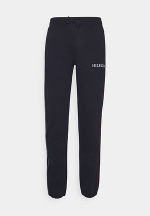Pantalon de survêtement noir avec le logo HILFIGER. Il possède une taille à cordon de serrage, des bandes latérales rouges et blanches, et des poignets élastiques aux chevilles.