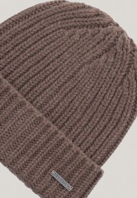 Brązowa dziana czapka z prążkowanym wzorem i podwiniętym mankietem. Posiada metalową metkę z napisem "PROCHINIK" z boku. Wykonana z miękkiej wełny.