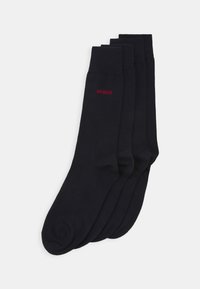 Schwarze Baumwollsocken mit gerippten Bündchen, ausgestattet mit einem kleinen roten "HUGO"-Logo. Jede Socke hat eine glatte, leicht dehnbare Textur.