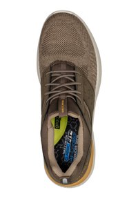 Zapatilla de deporte de texto marrón con parte superior de malla tejida, punta redonda, diseño de cordones y plantilla acolchada con un logo verde. Suela de goma.