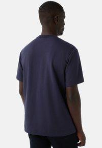 Marineblå bomulds t-shirt med afslappet pasform, rund hals og korte ærmer. Glat tekstur og enkelt design, set fra bagsiden.