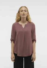 Top a maniche lunghe color prugna con scollo a V e maniche arrotolate, dotato di un tessuto testurizzato e un taglio comodo.