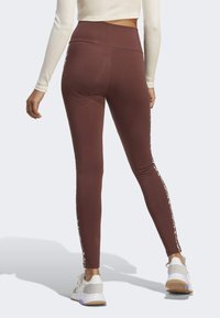 Vinröda leggings med hög midja, med vita sidopaneler och en figurnära design. Tillverkade av ett mjukt, elastiskt material.