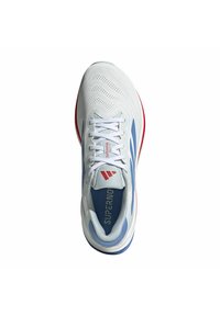Weißer Laufschuh mit blauen und roten Akzenten, atmungsaktives Mesh-Obermaterial, weiße Schnürsenkel und "Supernova"-Branding auf der Zunge und der Innensohle.