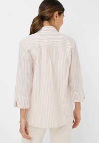 Lightweight, long-sleeve shirt with vertical beige and white stripes. Features a relaxed fit, split cuff, and gathered back detail for comfort.