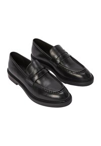 Mocassins en cuir noir au design épuré, avec une sangle plissée sur le dessus et un bout carré, complétés par une semelle texturée.