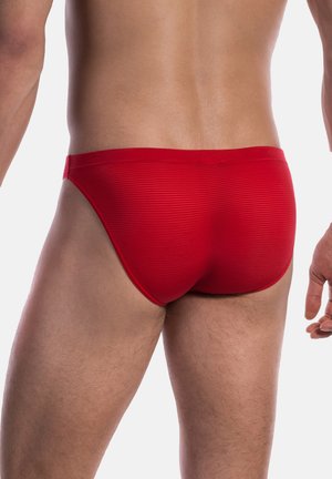 Costumi da bagno rossi con strisce testurizzate, caratterizzati da una vestibilità aderente e un'altezza bassa in vita, che dimostrano un design fluido e slanciato.