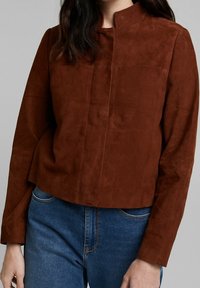 Bruine suède jas met een hoge kraag, lange mouwen en een cropped ontwerp. Opvallende gladde textuur en verstevigde stiksel details.