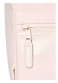 Light pink fabric backpack with a textured surface, featuring a matching zipper and a small fabric pull tab for easy access to the pocket.