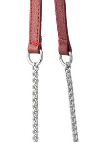 Cinghie in pelle rossa con cuciture visibili collegate a anelli di catena argentata, caratterizzate da una finitura testurizzata e accessori metallici.