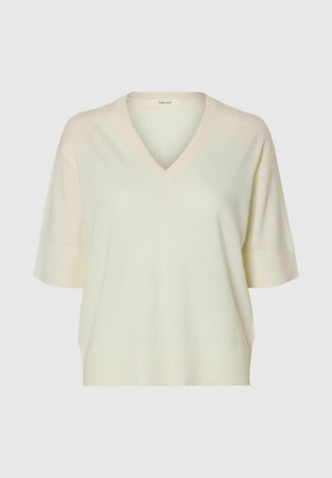 Maglione lavorato a maglia color crema con maniche corte, scollo a V, vestibilità ampia e polsini e orlo a coste su sfondo semplice.