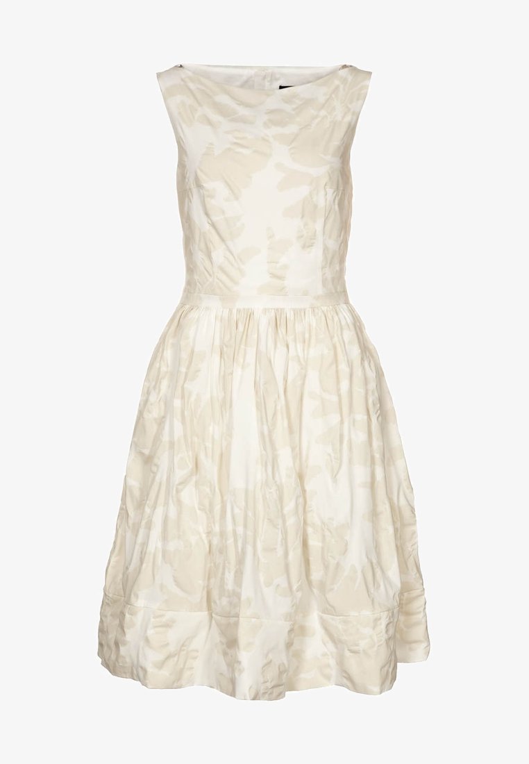 Robe blanche sans manches avec un motif floral texturé, corsage ajusté et jupe froncée, présentant un léger éclat et une silhouette mi-longue jusqu'au genou.