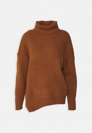 Pull col roulé en maille côtelée marron à manches longues avec un ourlet asymétrique sur un fond clair uni.
