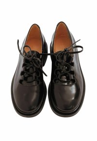 Un paio di eleganti scarpe da uomo in pelle nera lucida con lacci, dalla punta arrotondata e fodera interna color caramello, viste dall'alto.