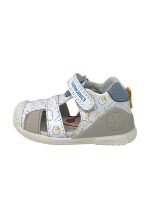 Sandalo bianco e grigio per bambino piccolo con fantasie a cartone animato gialle e grigie, cinturino in velcro etichettato "biomecanics" e suola in gomma con dettaglio del logo.