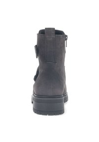 Bottine en daim noir avec bout arrondi, fermeture éclair latérale et détail de boucle ajustable sur le côté extérieur. Semelle épaisse en caoutchouc.