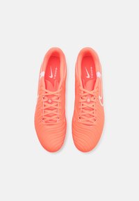 Nike Tiempo jalkapallokengät kirkkaan korallinvärisellä synteettisellä yläosalla, tekstuuripinnoilla, valkoisilla yksityiskohdilla ja matching-nauhoilla.