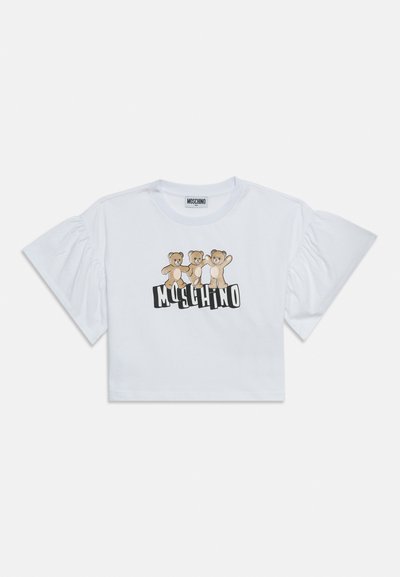 Λευκό cropped T-shirt με κοντά μανίκια που συγκεντρώνονται, με τρία αρκουδάκια πάνω από το κείμενο «MOSCHINO» με έντονα μαύρα γράμματα.