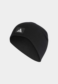 Zwarte beanie van zachte stof, met een aansluitend ontwerp en een rechthoekig logo-label met drie strepen. Gladde textuur overal.